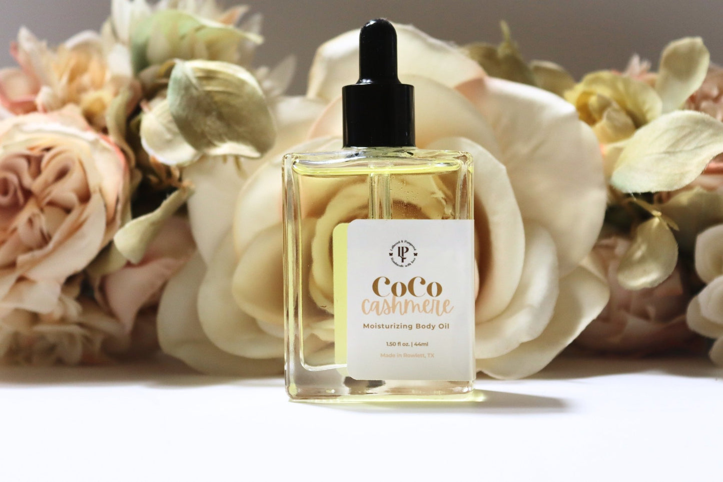 Coco Cashmere body oil in a clear glass bottle with scent notes of coconut, cocoa butter and cedarwood