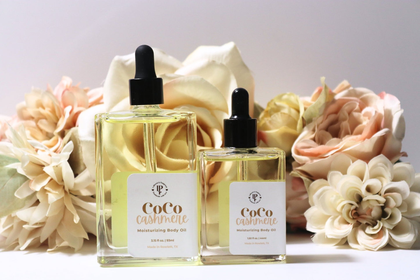 Coco Cashmere body oil in a clear glass bottle with scent notes of coconut, cocoa butter and cedarwood