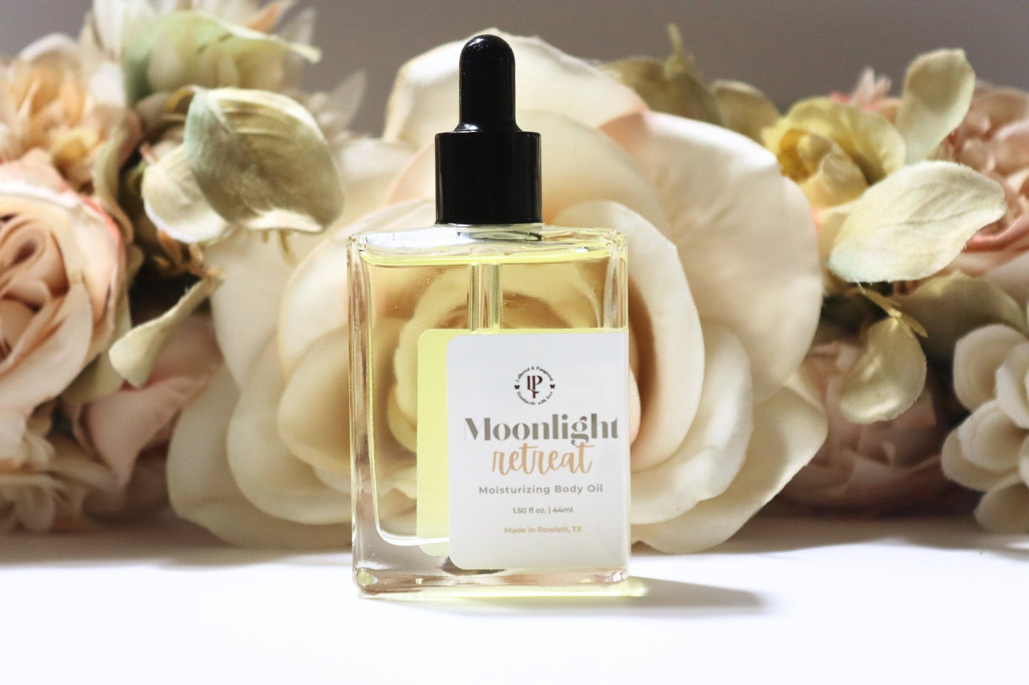 Moonlight Retreat body oil in a clear bottle, with scent notes of Star Anise, Balsamic Reduction & Sweet Vanilla.