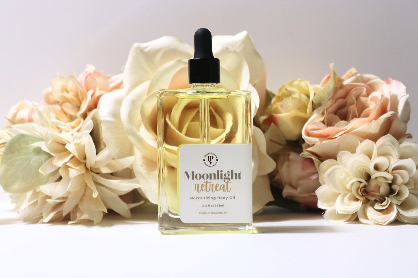 Moonlight Retreat body oil in a clear bottle, with scent notes of Star Anise, Balsamic Reduction & Sweet Vanilla.