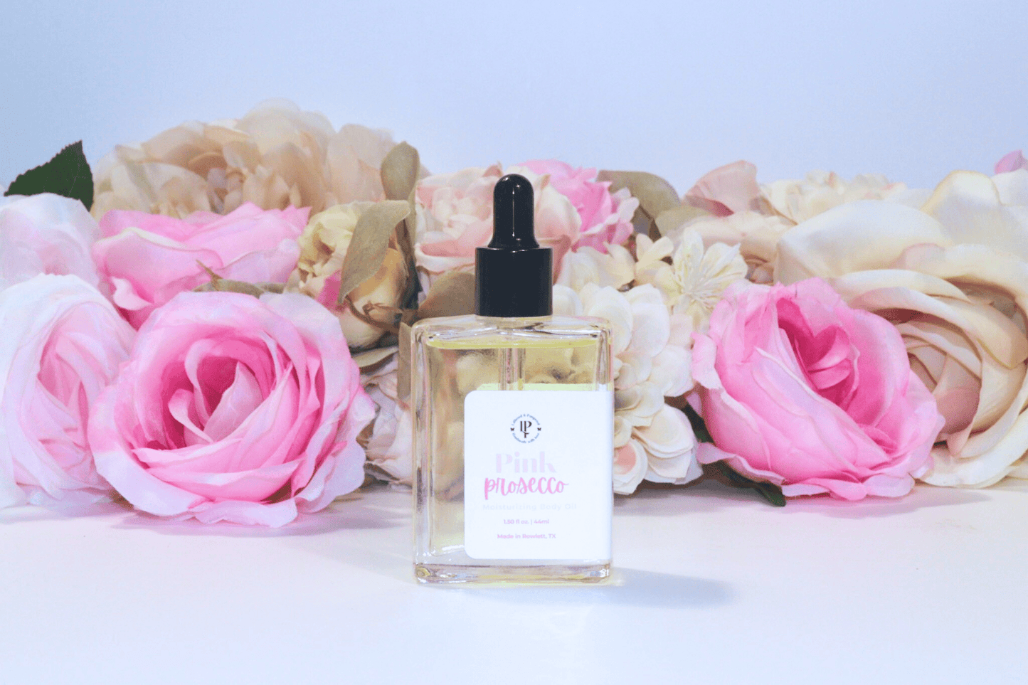 Pink Prosecco body oil in a clear glass bottle with scent notes of Citrus, Cranberry, Champagne and Musk
