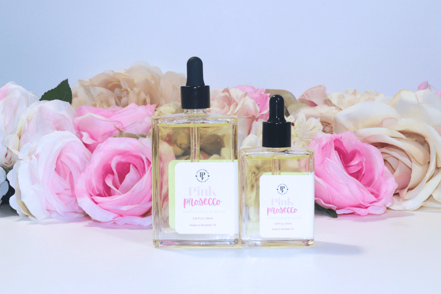 Pink Prosecco body oil in a clear glass bottle with scent notes of Citrus, Cranberry, Champagne and Musk