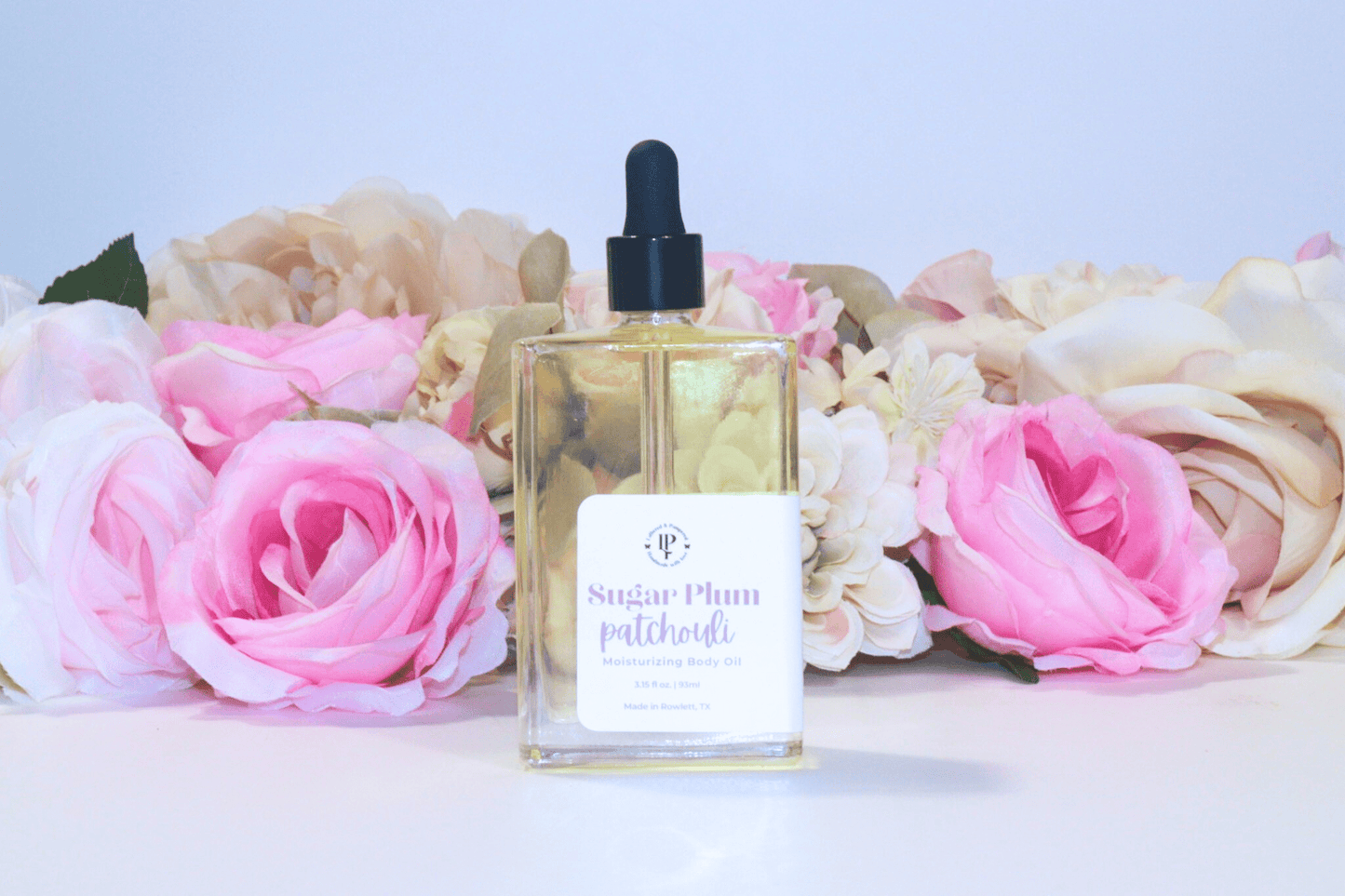 Sugar Plum Patchouli body oil in a clear glass bottle with scent notes of Ripe Plums, Wild Berries, Patchouli and Sandalwood
