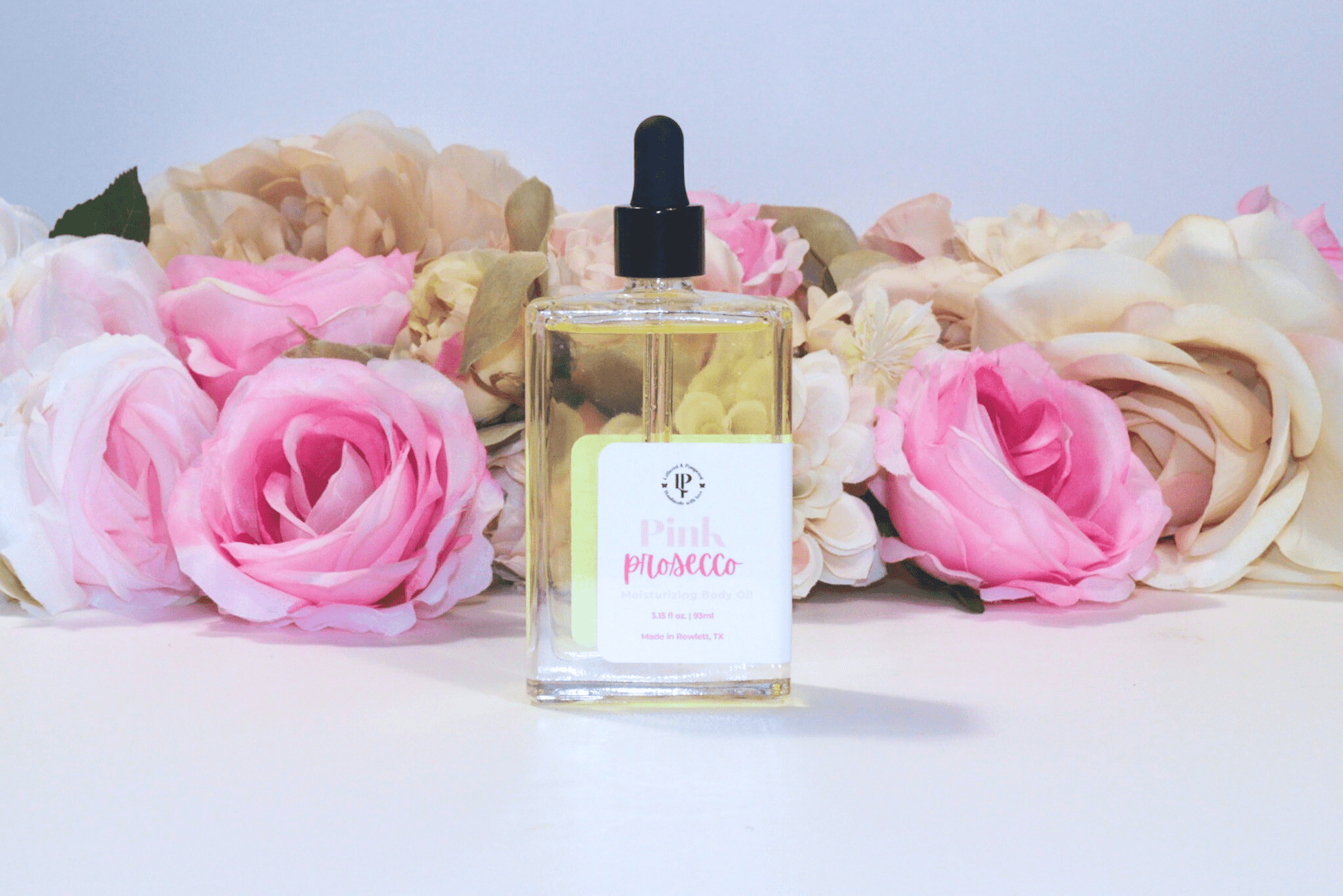 Pink Prosecco body oil in a clear glass bottle with scent notes of Citrus, Cranberry, Champagne and Musk
